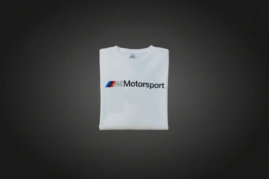 A white BMW Motorsport sleeveless top or poncho with the vertical black 'BMW Motorsport' text and the round BMW logo printed on the front, shown against a solid gray background.